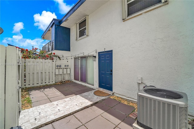 view of patio with central air condition unit and fence