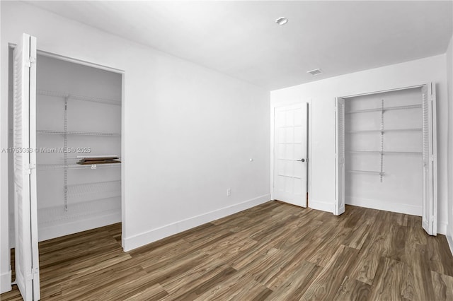 unfurnished bedroom featuring visible vents, baseboards, and wood finished floors