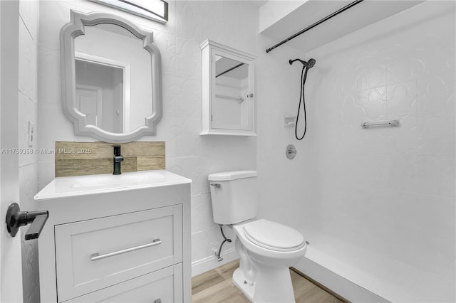 full bathroom featuring vanity, walk in shower, wood finished floors, and toilet