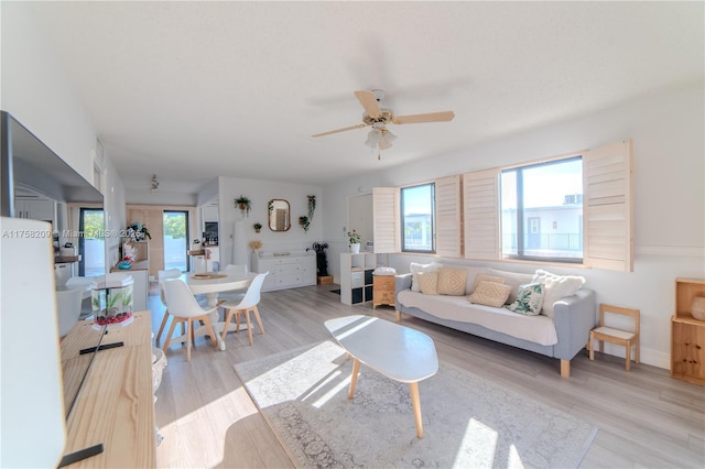 living room with light wood-type flooring and a ceiling fan