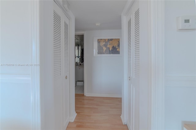 hall featuring baseboards and light wood-style floors