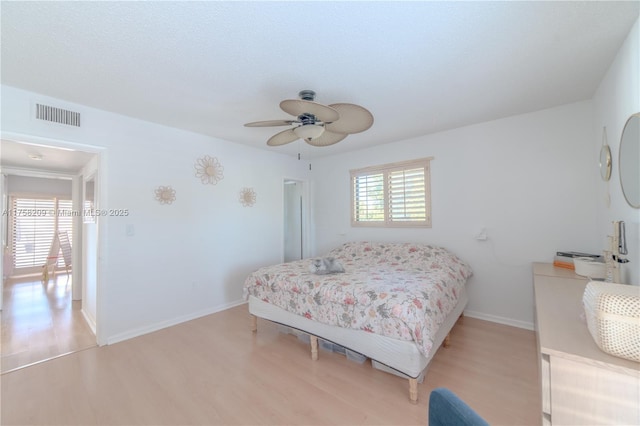 bedroom with light wood-type flooring, baseboards, multiple windows, and visible vents