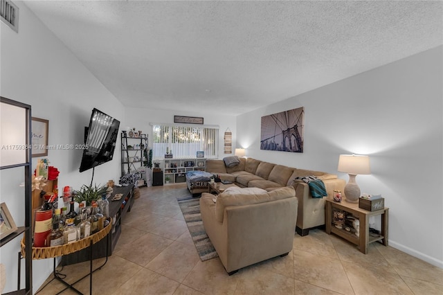 living area featuring visible vents, a textured ceiling, baseboards, and light tile patterned flooring