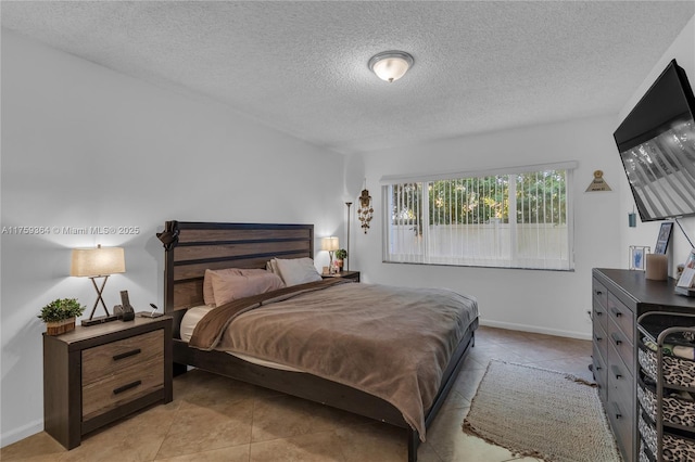 bedroom with baseboards, a textured ceiling, and light tile patterned flooring