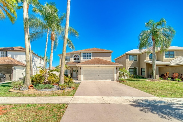 view of front of property with a front yard, driveway, an attached garage, and stucco siding