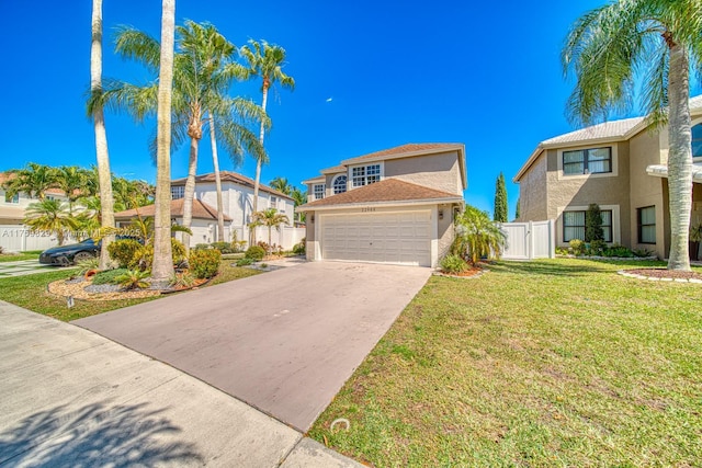 view of front of home featuring concrete driveway, an attached garage, fence, a front lawn, and stucco siding