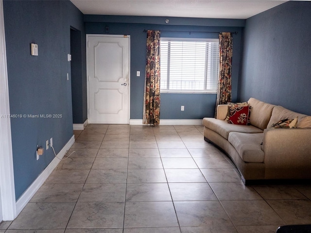 unfurnished living room with baseboards and tile patterned floors