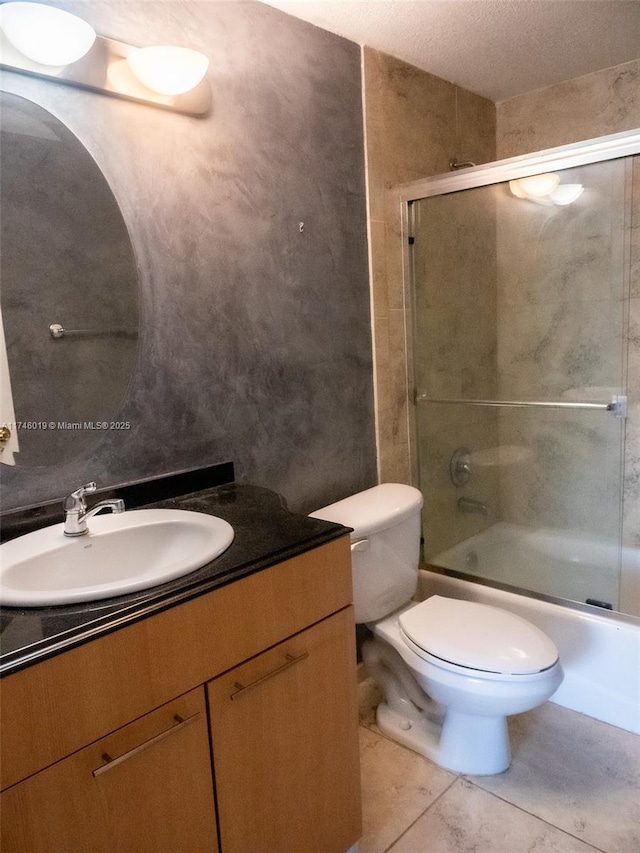 full bathroom featuring toilet, tile patterned floors, bath / shower combo with glass door, and vanity