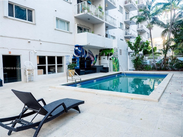 community pool featuring a patio and fence