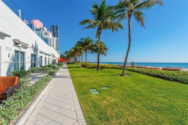 view of property's community with a water view and a yard