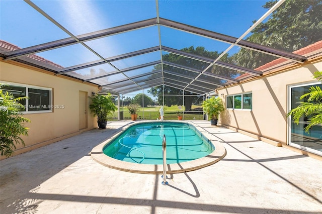 swimming pool with a patio and glass enclosure