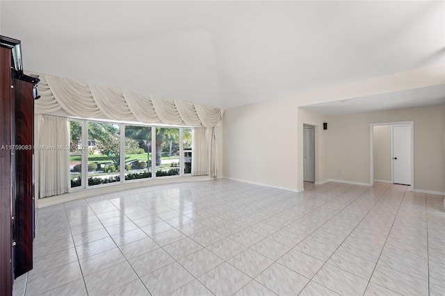 spare room featuring baseboards and light tile patterned floors