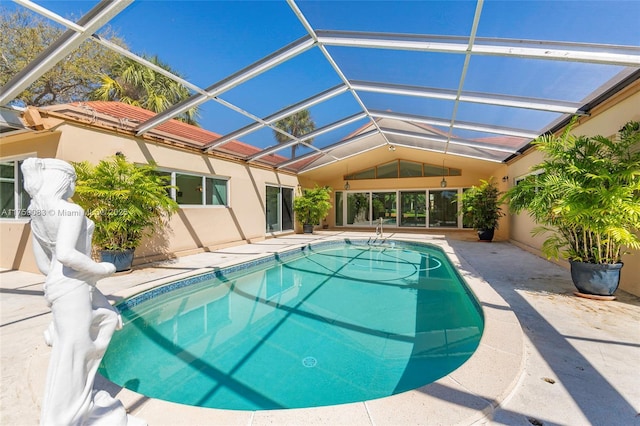 outdoor pool with glass enclosure and a patio area
