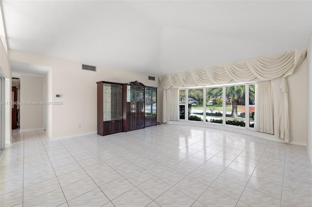 unfurnished living room with visible vents, baseboards, and light tile patterned floors