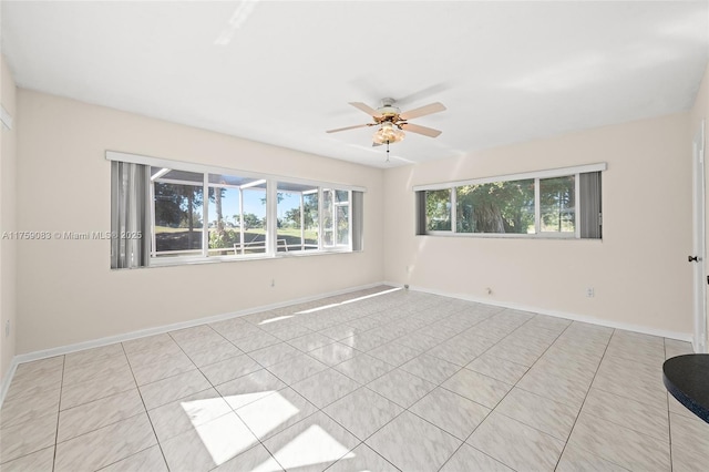 unfurnished room featuring ceiling fan and baseboards