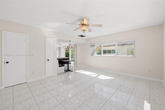 unfurnished living room featuring ceiling fan, baseboards, and light tile patterned floors