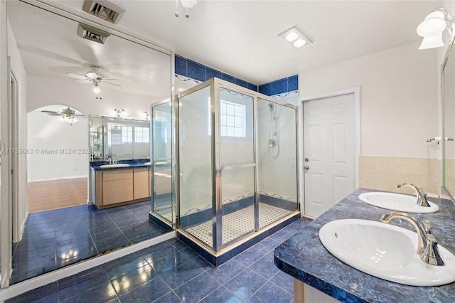 full bath with double vanity, a sink, and a shower stall