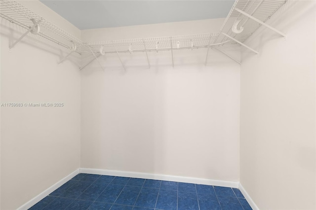 walk in closet with dark tile patterned flooring