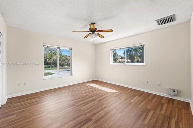 empty room featuring wood finished floors, a ceiling fan, and baseboards