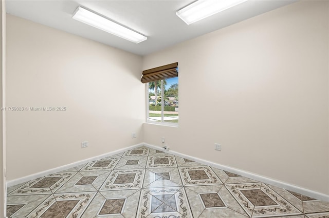 unfurnished room featuring baseboards and light tile patterned flooring