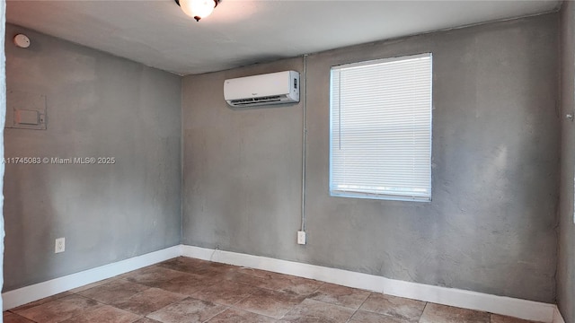 empty room featuring baseboards and an AC wall unit