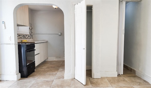 bathroom featuring tasteful backsplash, baseboards, and tile patterned floors