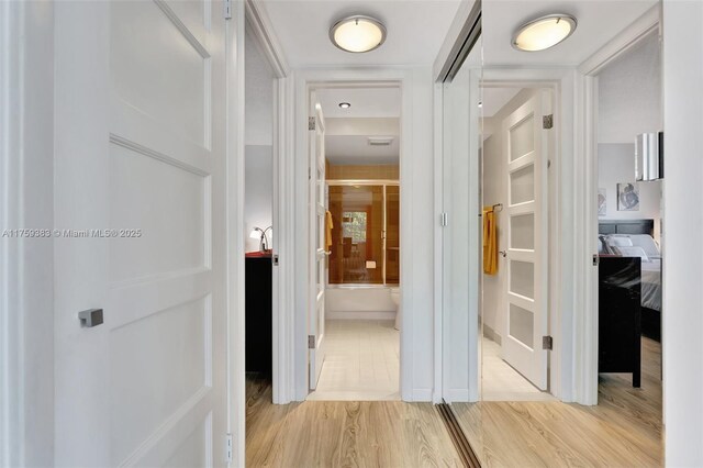 hall with light wood-style floors and visible vents