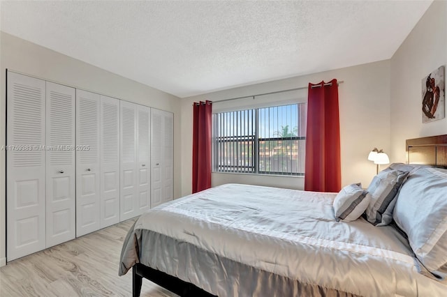 bedroom with a textured ceiling, a closet, and light wood-style floors