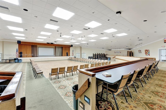 rec room with a paneled ceiling, visible vents, crown molding, and light carpet