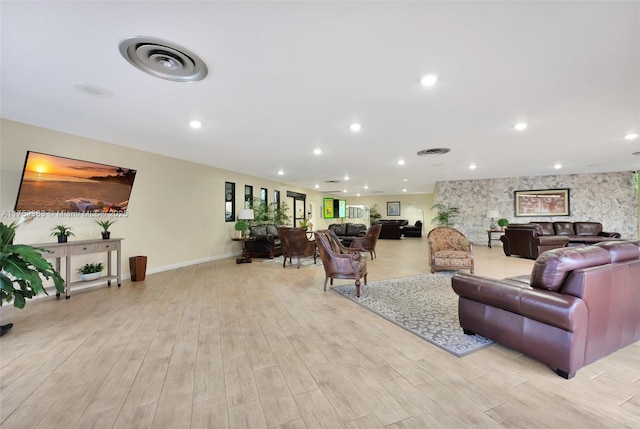 living room with light wood-type flooring, baseboards, and recessed lighting