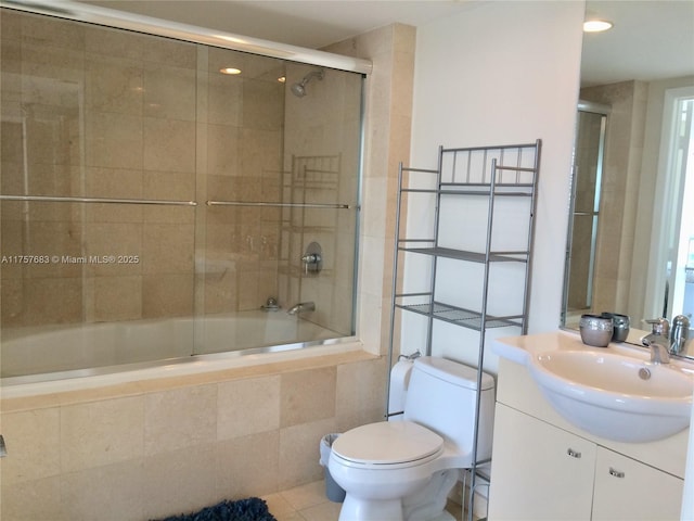 bathroom featuring tile patterned flooring, tiled shower / bath combo, vanity, and toilet