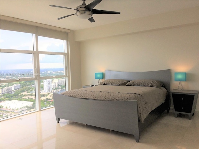 bedroom featuring expansive windows, a ceiling fan, and a city view