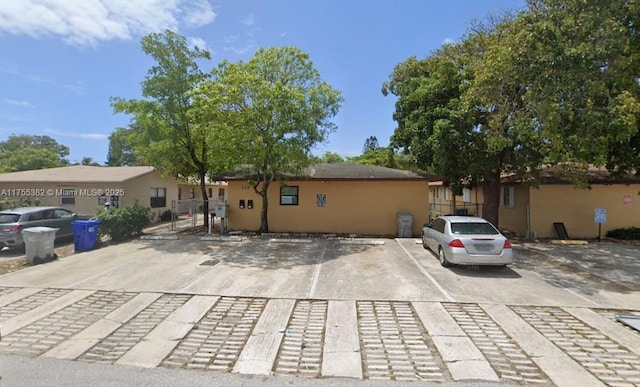 exterior space with uncovered parking and stucco siding