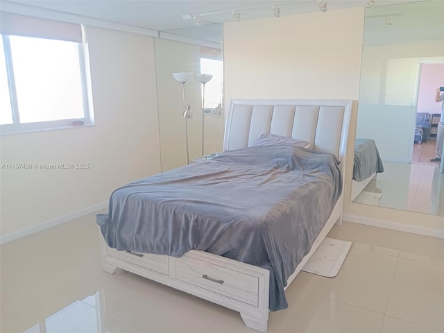 bedroom with baseboards and tile patterned floors