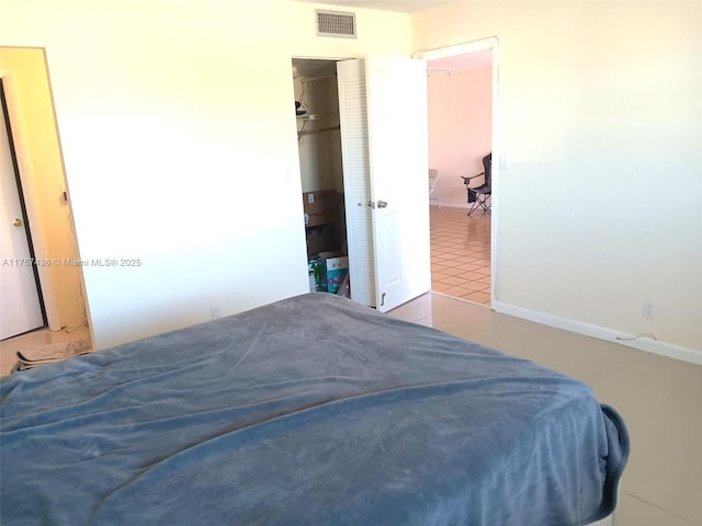 tiled bedroom featuring visible vents and a closet