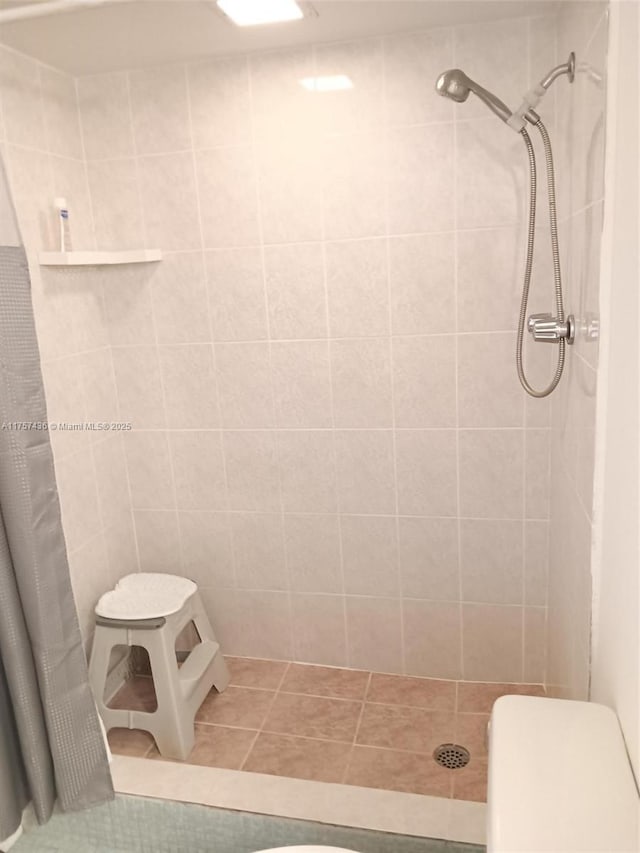 bathroom with toilet, a stall shower, and tile patterned floors