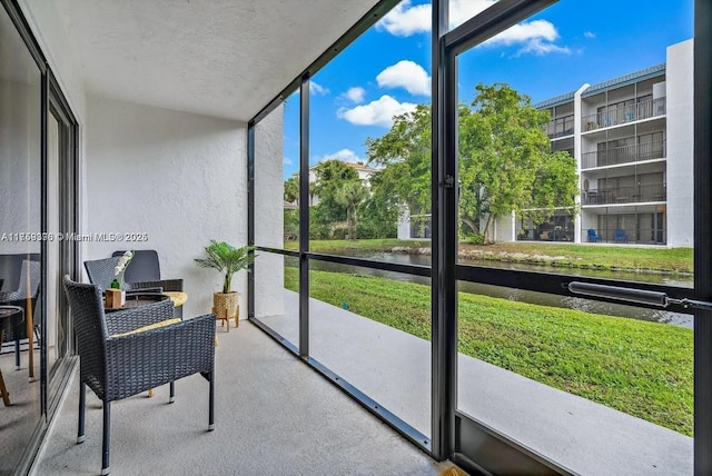 sunroom / solarium featuring a water view