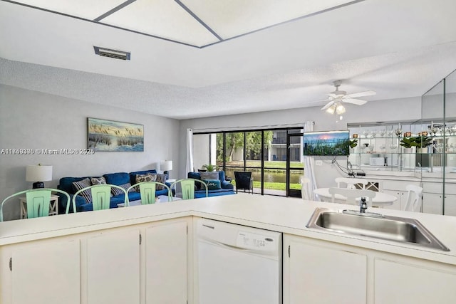 kitchen with a textured ceiling, a sink, visible vents, open floor plan, and dishwasher