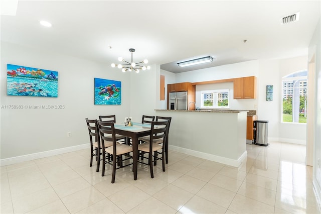 dining area featuring a chandelier, light tile patterned floors, visible vents, and baseboards