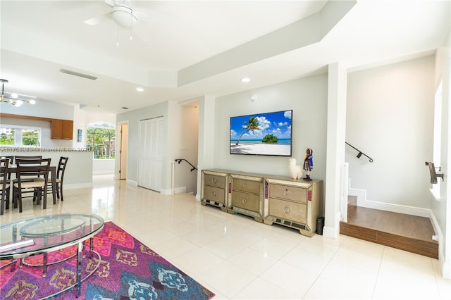 living area featuring light tile patterned floors, visible vents, and baseboards