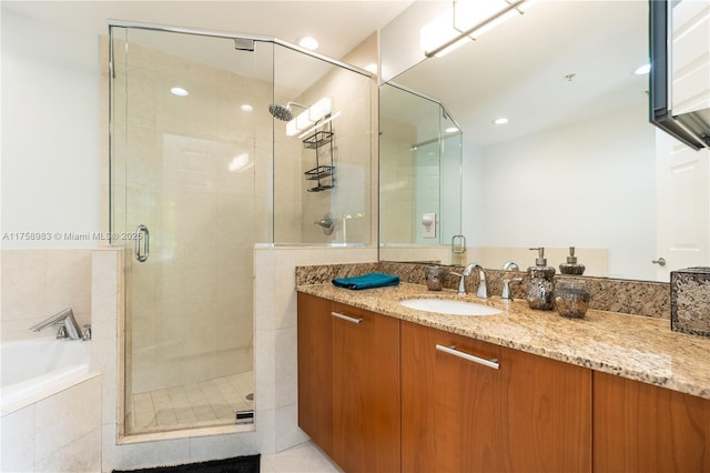 bathroom with tile patterned flooring, vanity, a shower stall, a bath, and recessed lighting