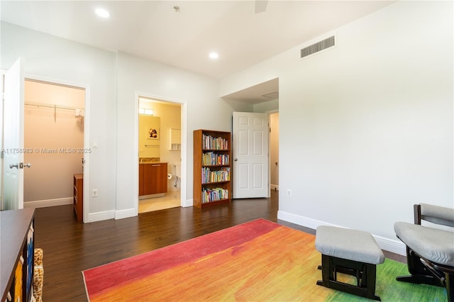 living area featuring baseboards, wood finished floors, visible vents, and recessed lighting