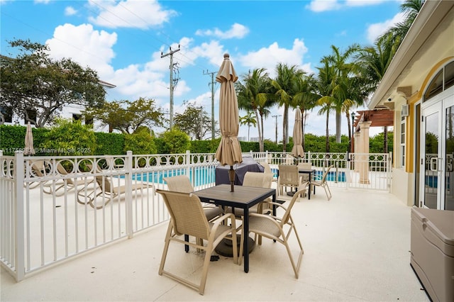 view of patio featuring a fenced in pool, outdoor dining space, and fence