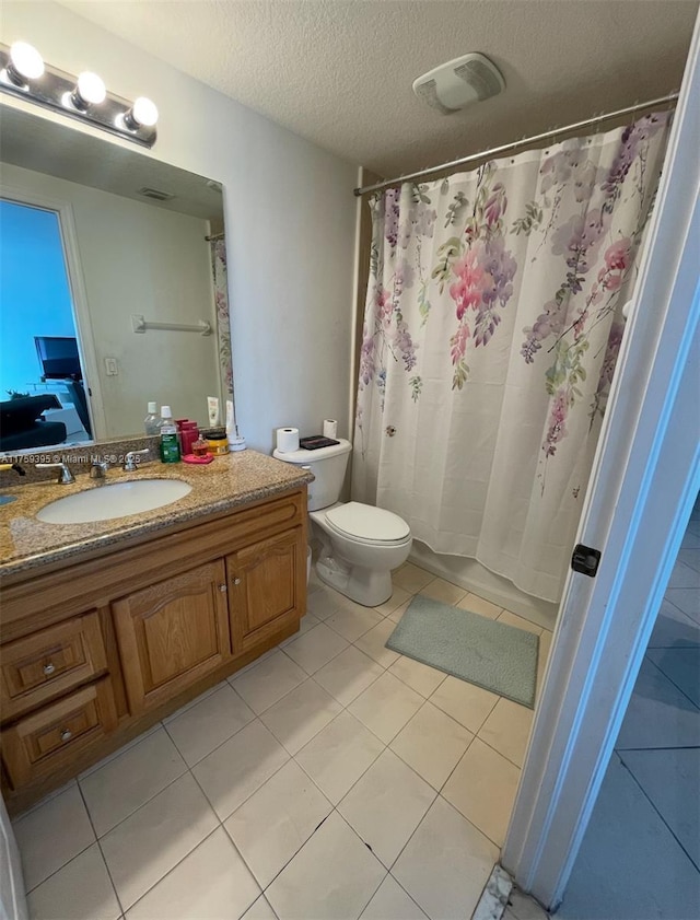 full bathroom featuring visible vents, toilet, tile patterned floors, a textured ceiling, and vanity