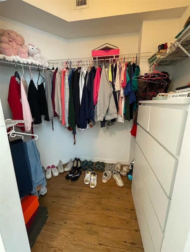 walk in closet with wood finished floors and visible vents