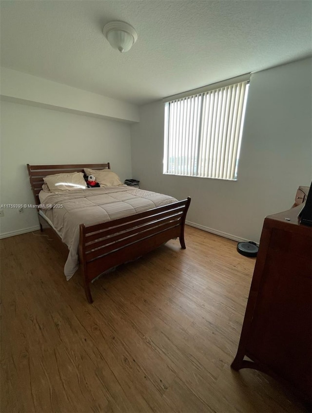 bedroom featuring baseboards and wood finished floors