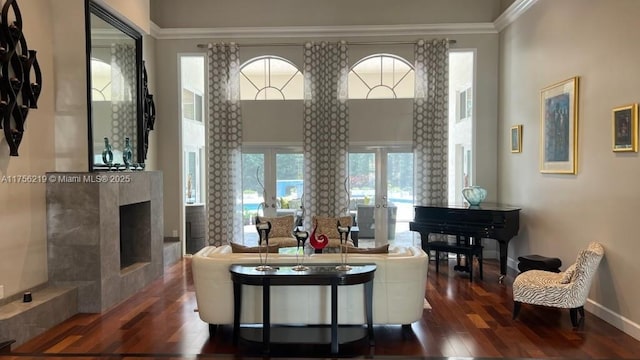 living area featuring dark wood-style floors, a fireplace, baseboards, and french doors