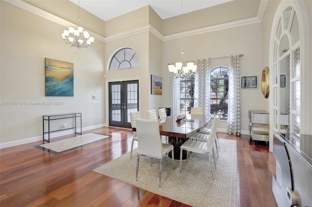 dining area featuring a chandelier, french doors, a high ceiling, and wood finished floors