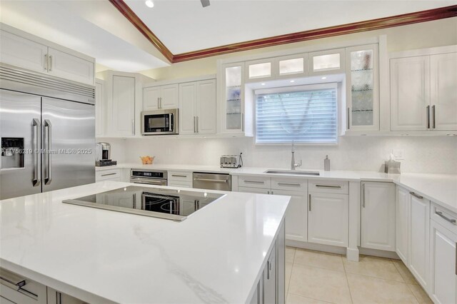 12200 SW 2nd St, Plantation, FL 33325 - kitchen featuring built in appliances, a sink, vaulted ceiling, white cabinetry, and light countertops