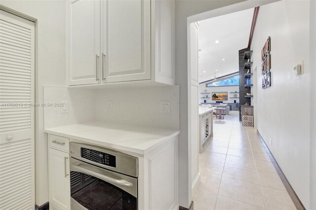 12200 SW 2nd St, Plantation, FL 33325 - kitchen featuring stainless steel oven, light tile patterned floors, baseboards, and white cabinets